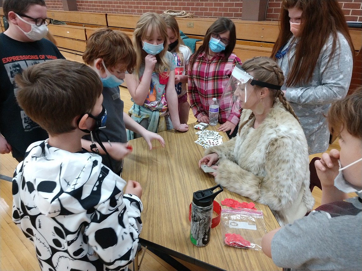 Pinehurst Elementary School fourth-grade teacher Mrs. Derbyshire, engages students in a game of chance similar to how the frontier men of old days would gamble, during the school's Mountain Man Rendezvous.