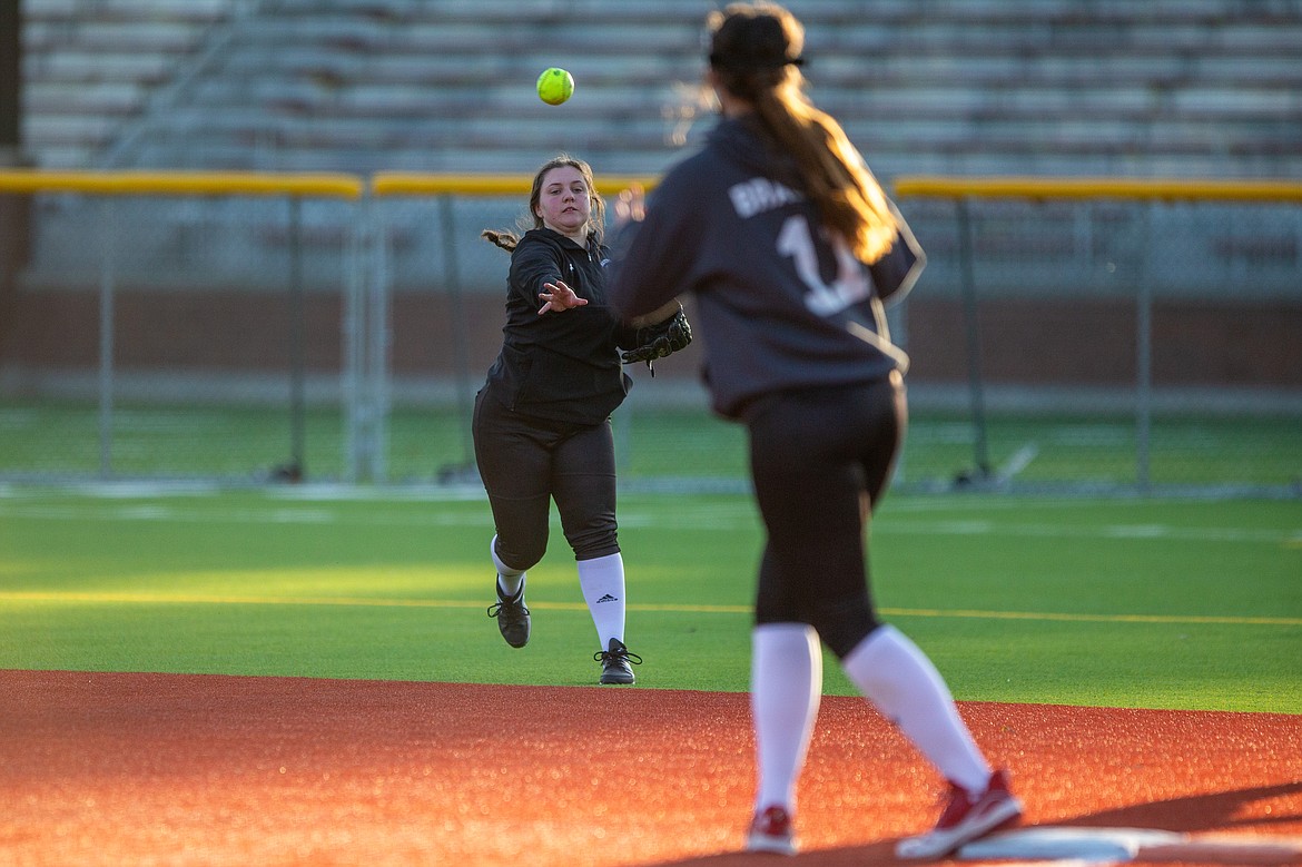 Kinzie Ward (left) makes a throw to first baseman Kaylee Brackett on Tuesday.