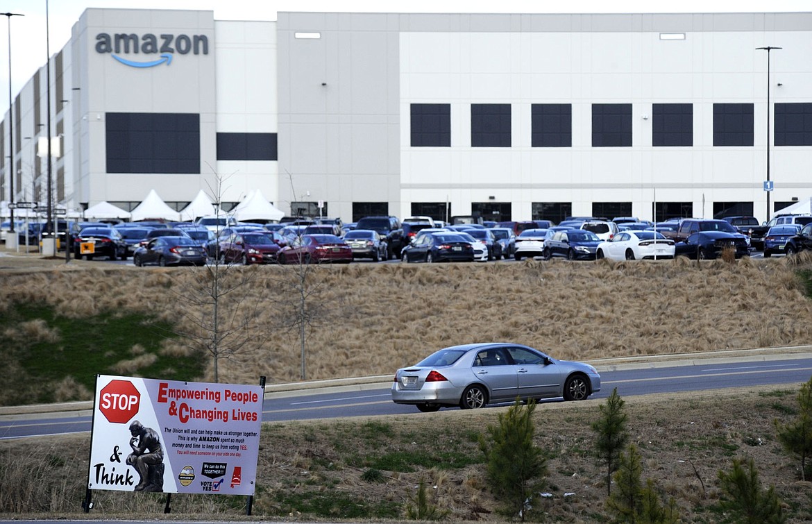 This Feb. 9, 2021 photo file photo, a car enters an Amazon facility where labor is trying to organize workers in Bessemer, Ala. Organizers are pushing for some 6,000 Amazon workers to join the Retail, Wholesale and Department Store Union on the promise it will lead to better working conditions, better pay and more respect. Amazon is pushing back, arguing that it already offers more than twice the minimum wage in Alabama and workers get such benefits as health care, vision and dental insurance without paying union dues.