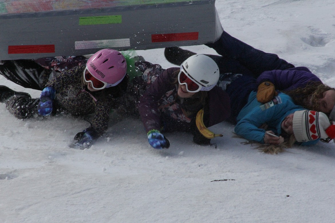 Joecy, Makia, Xadrian and Annemarie wipe out during a toboggan ride Tuesday morning at Schweitzer.