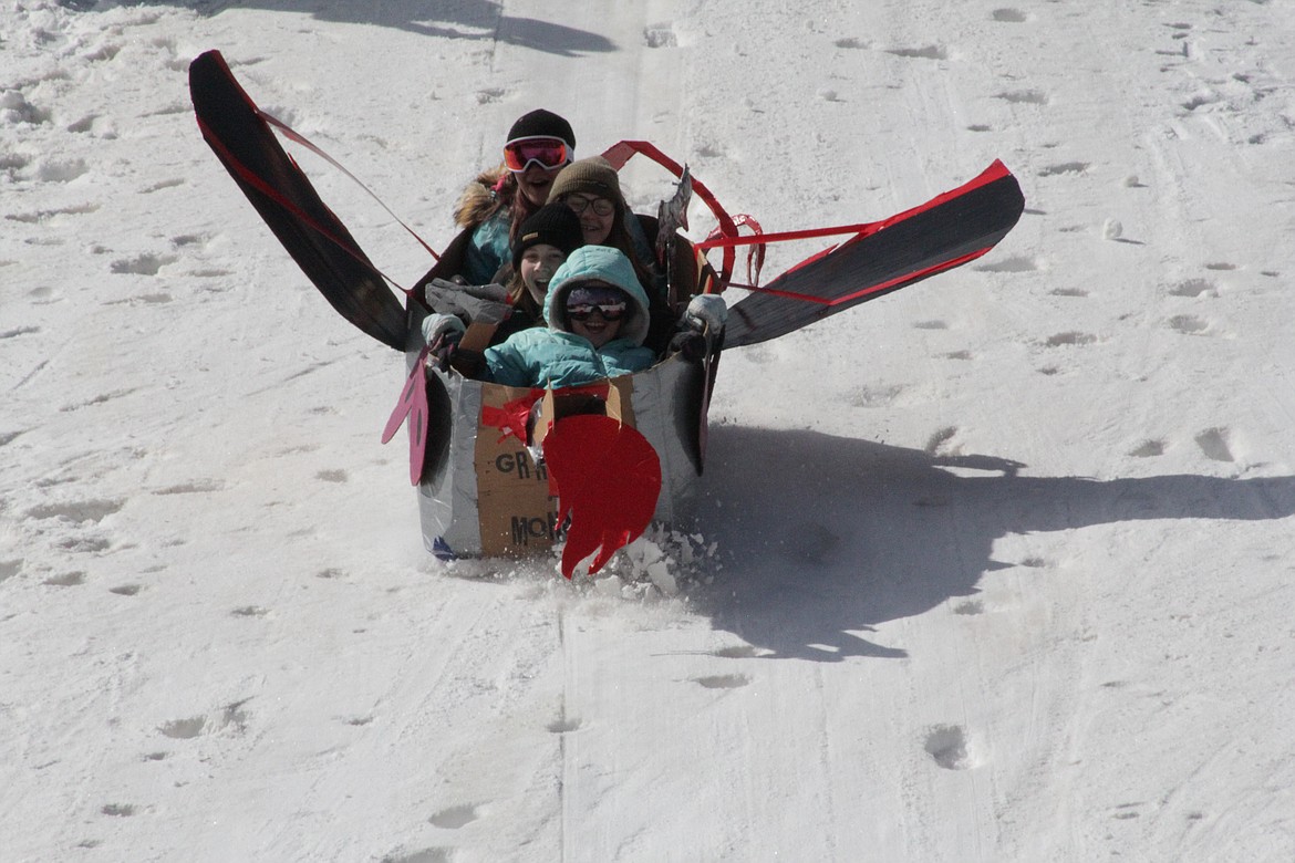 Elka, Rowin and Lia and another student at the Homeschool Academy slide down the hill in their "monster"-themed toboggan.