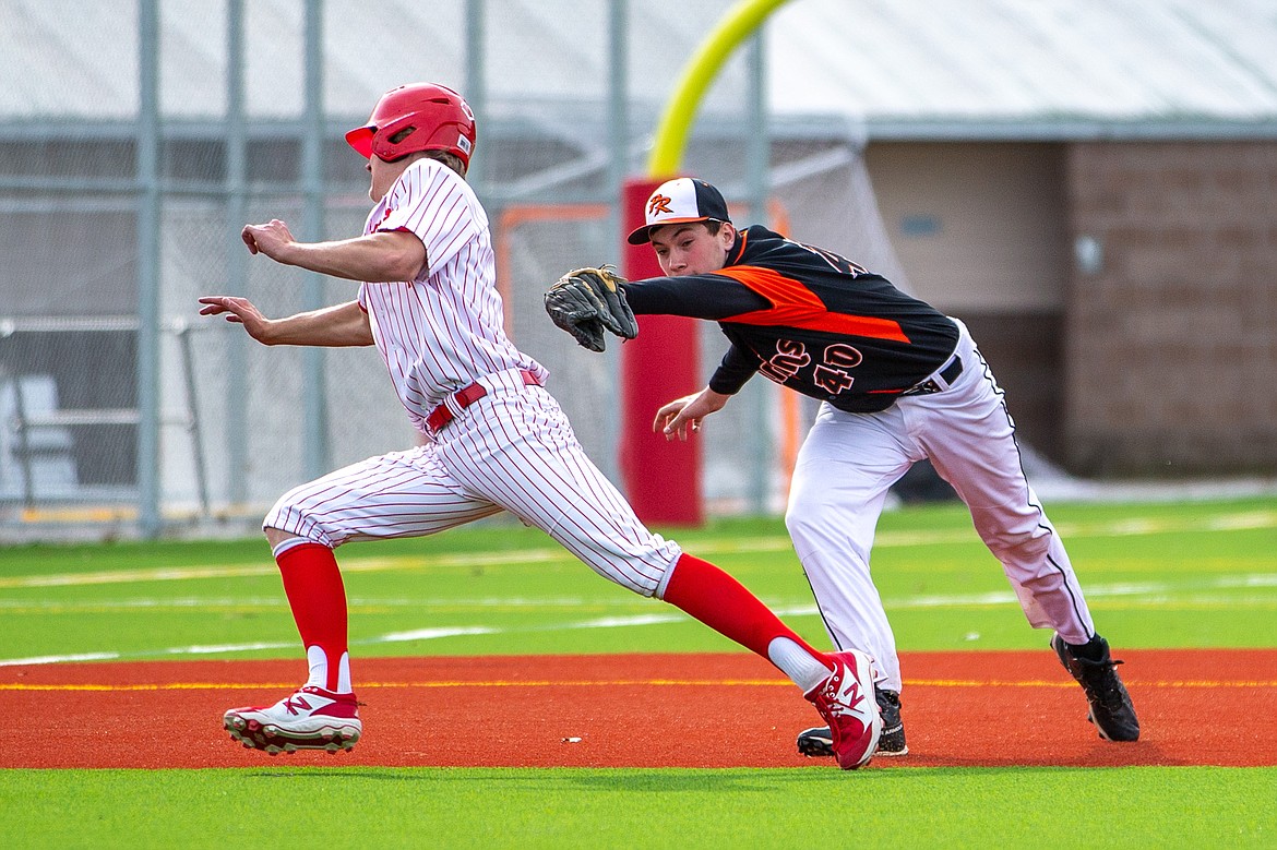 Sandpoint's Cody Newhart (left) avoids being tagged by Priest River's Landon Reynolds on Thursday.