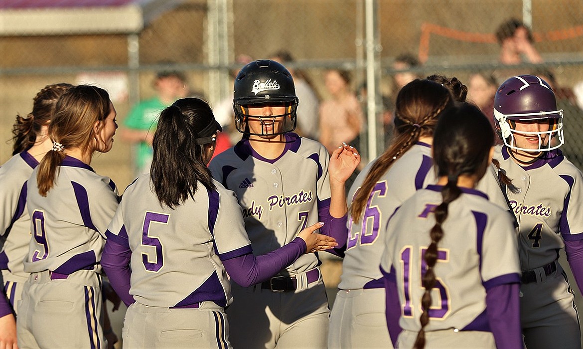 Josie Caye (7) is greeted at home plate following her home run at Hamilton. (Courtesy of Bob Gunderson)