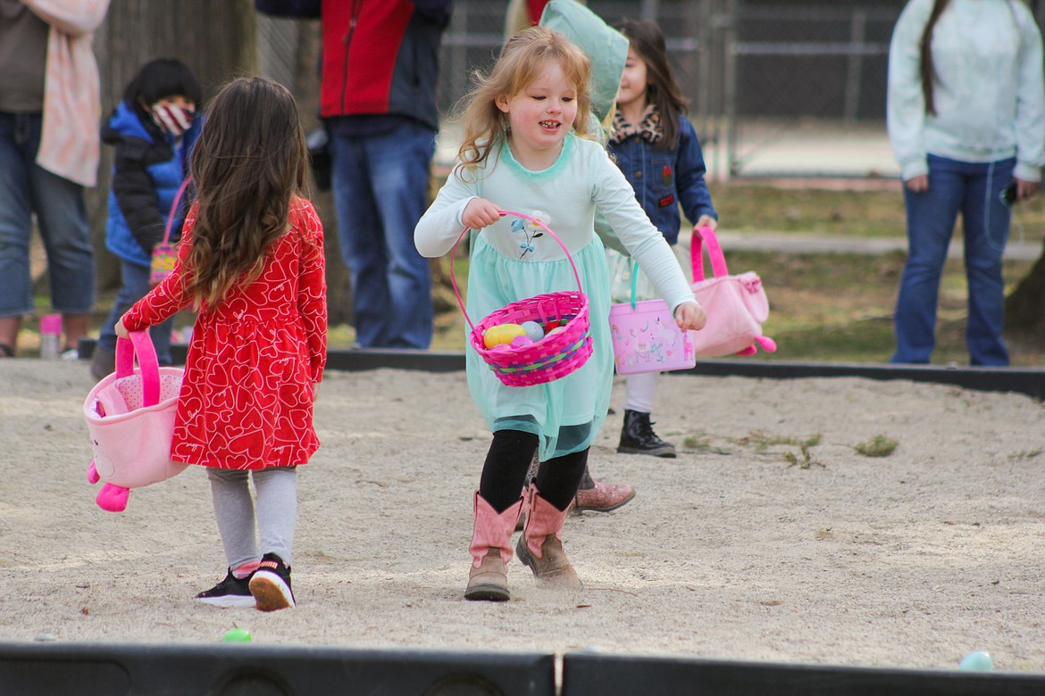 A girl runs with a basket full of eggs Saturday at the egg hunt.