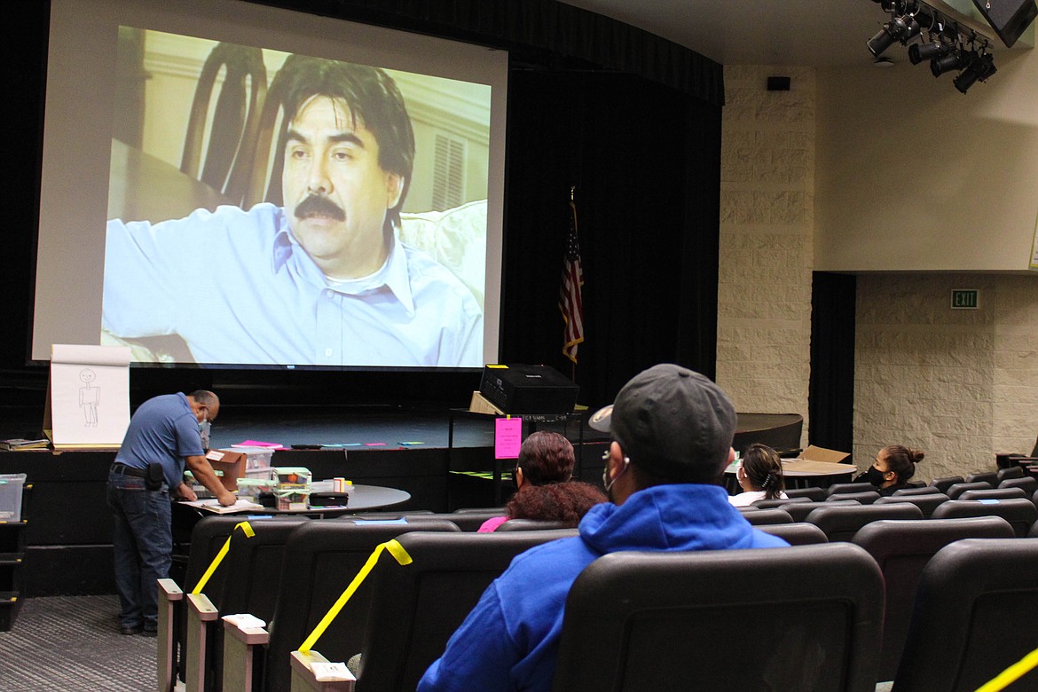 Parents watch a video on improving family dynamics at the Strengthening Families Program at Quincy Middle School on Friday.