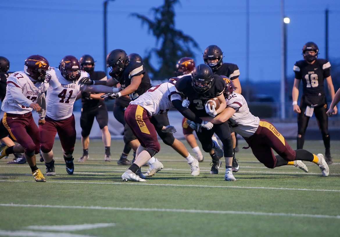 Royal's Kaleb Hernandez powers his way forward with Moses Lake defenders draped all over him on Friday night at Royal High School.