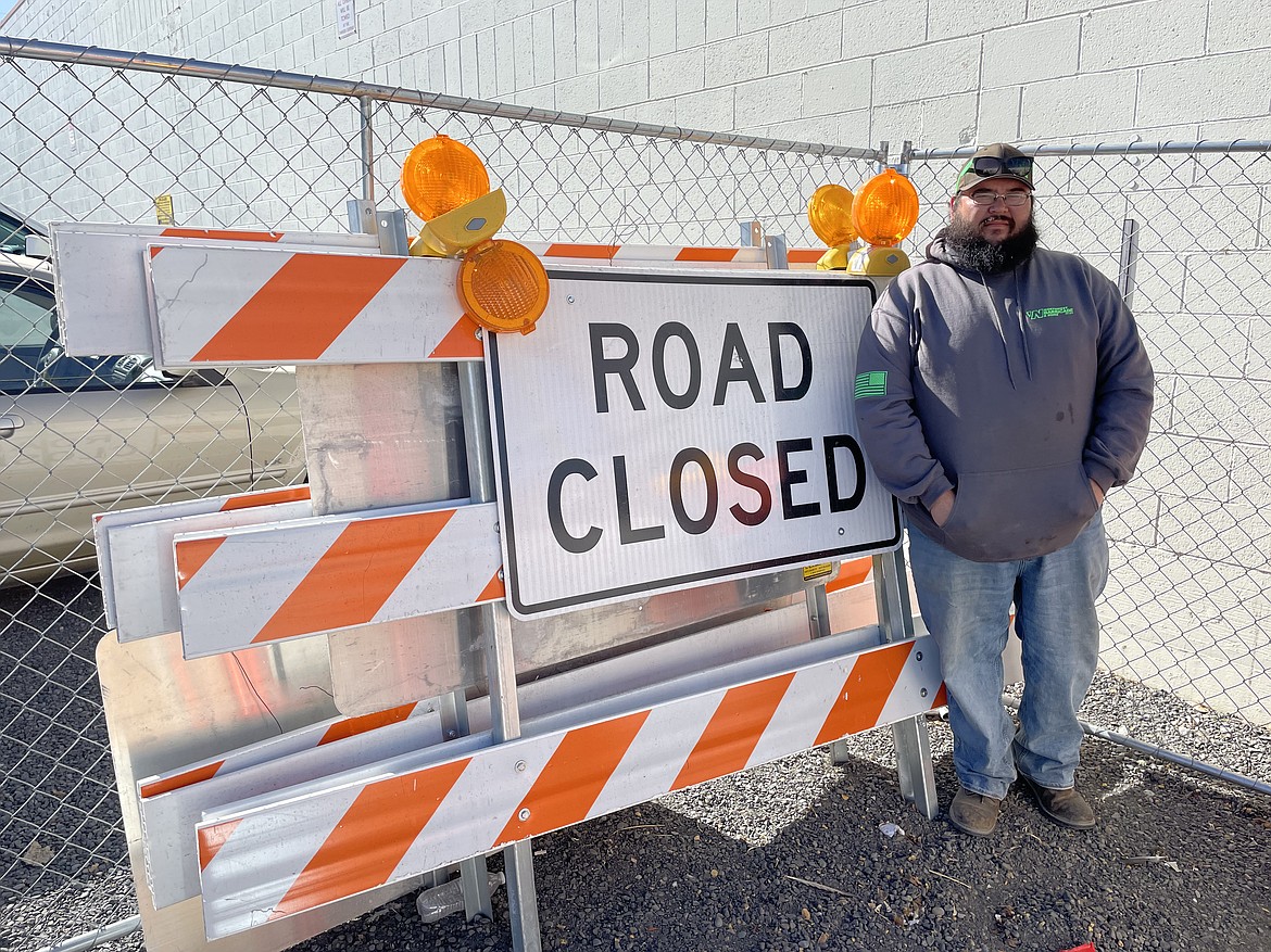 Thomas Barnes, manager of the newly opened Moses Lake location of Northwest Barricade & Signs, Safety and Apparel, with one of several Type III Barricades the company can lease out to road crews and utility crews doing construction work.