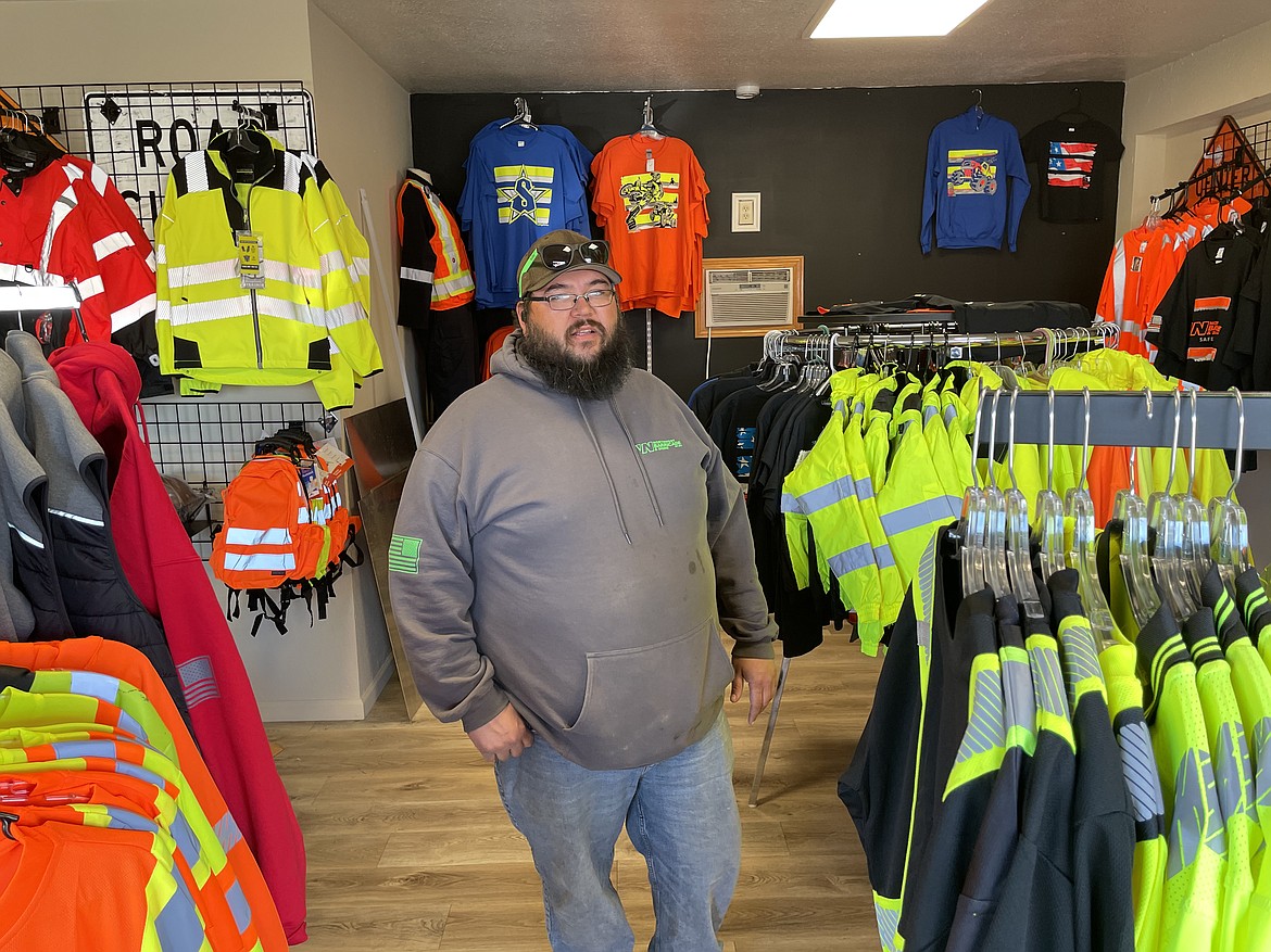 Thomas Barnes, manager of Northwest Barricade and Signs in Moses Lake, with a sample of the reflective shirts, vests and jackets the company sells.