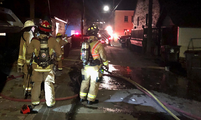 Shoshone County Fire District No. 1 crews gather near the affected structure on Cedar Street Friday night.