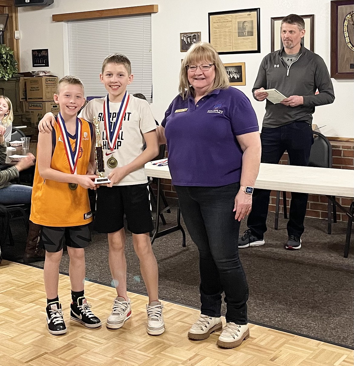 Courtesy photo
Maddox Hodges, left, and Micah Hodges won the Waide Hamner (Top Gun) Award as the top boys overall scorer at the Coeur d'Alene Elks Hoop Shoot held Feb. 20 at The Courts at Real Life in Post Falls. Also pictured is Debbi Nadrchal, Elks Exalted Ruler, and Todd Stoddard, Hoop Shoot director.