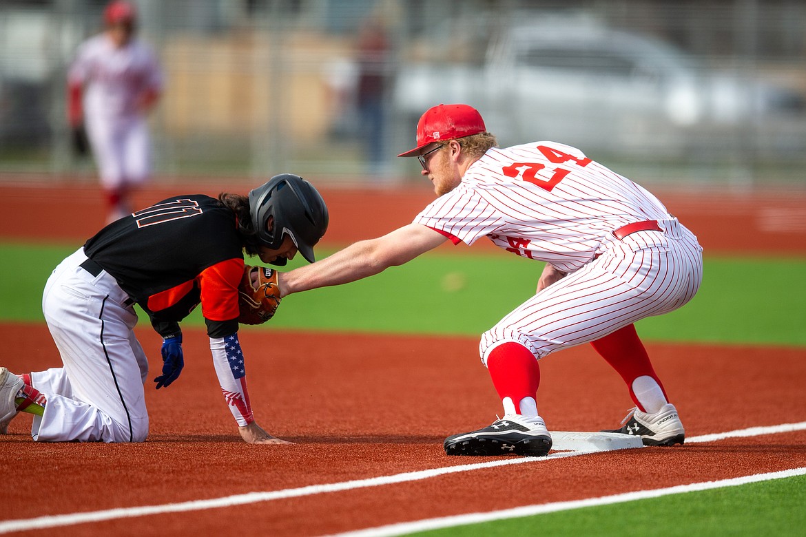 Sandpoint's Ethan Butler tags Priest River's Gavin Doster at first base last Thursday.