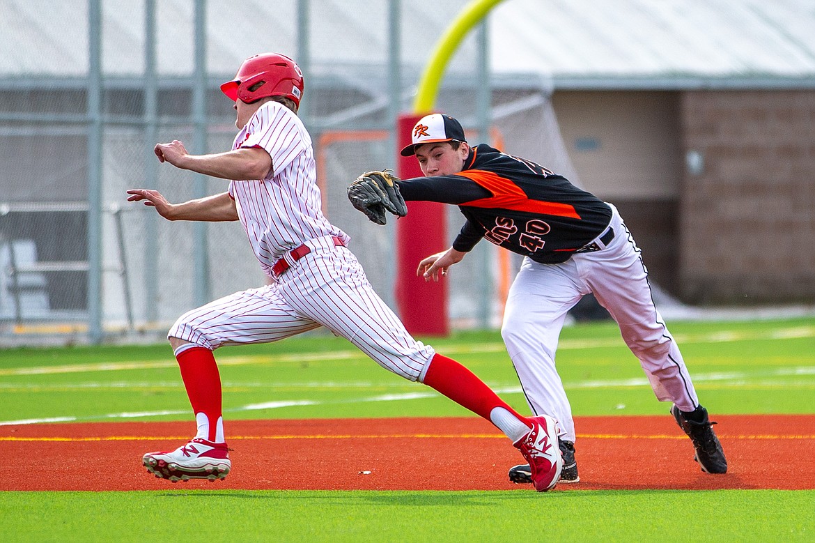 Sandpoint's Cody Newhart (left) avoids being tagged by Priest River's Landon Reynolds last Thursday.