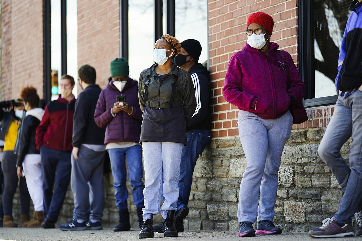 In this March 29, 2021, file photo, people wearing face masks as a precaution against the coronavirus wait in line to receive COVID-19 vaccines at a site in Philadelphia. Nearly half of new coronavirus infections nationwide are in just five states, including Pennsylvania — a situation that puts pressure on the federal government to consider changing how it distributes vaccines by sending more doses to hot spots.