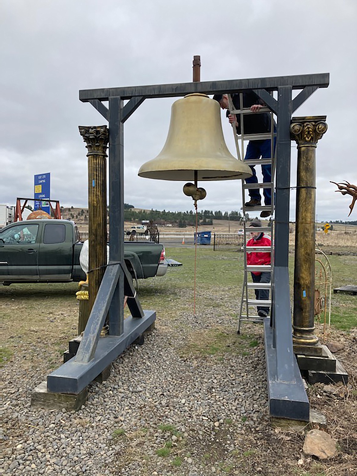 Will Valentine and Bob Camp inspect the old Sandpoint City Hall bell as it sits outside Way Out West Antiques in Spokane.