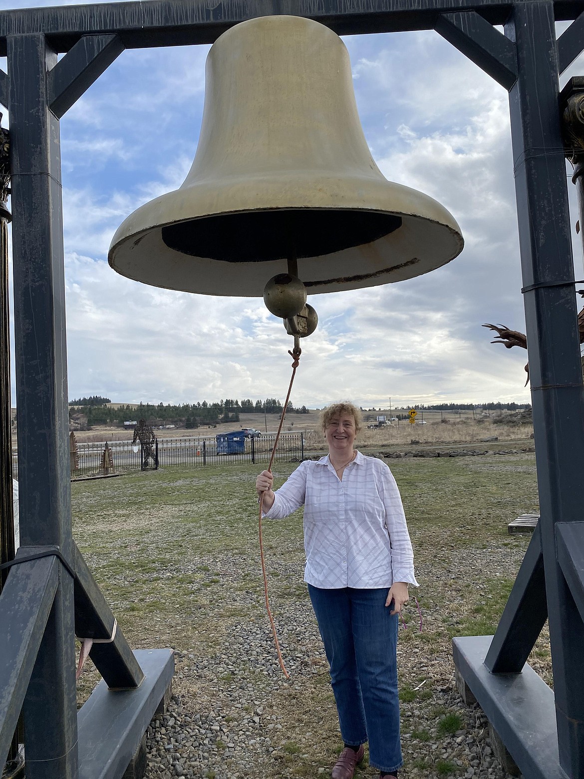 Karin Wedemeyer rings a bell which once sat atop Sandpoint City Hall, now the Music Conservatory of Sandpoint. After missing for decades, the bell was discovered at Way Out West Antiques and is headed home to Sandpoint.