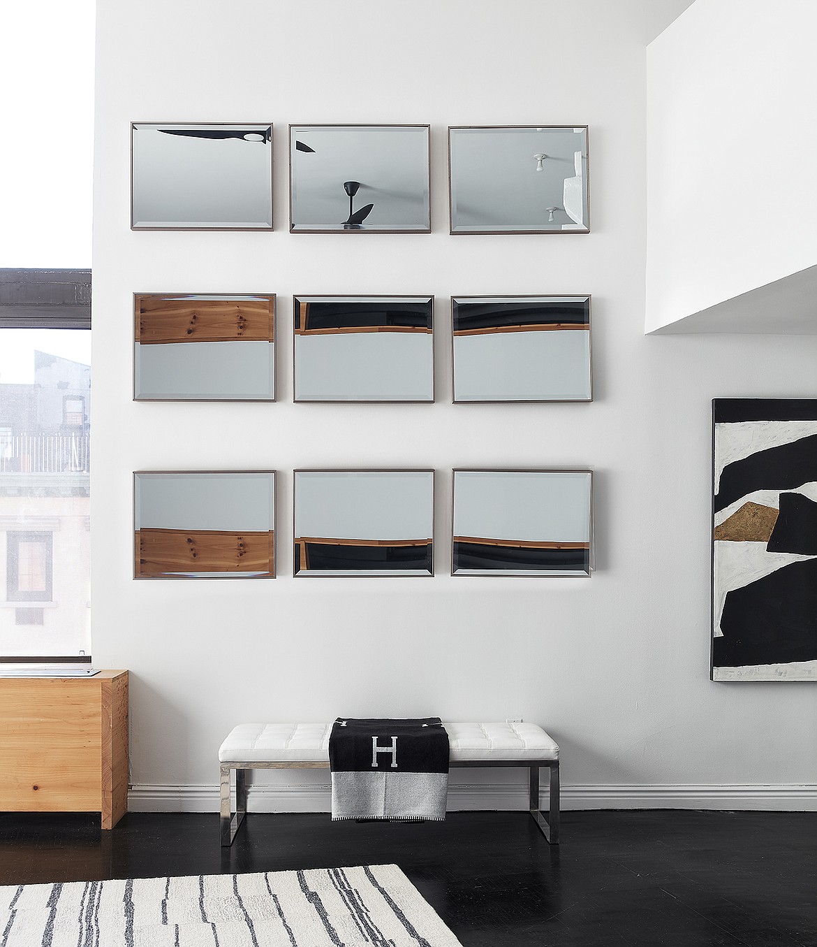 Small mirrors in a grid help to reflect light in this loft space.