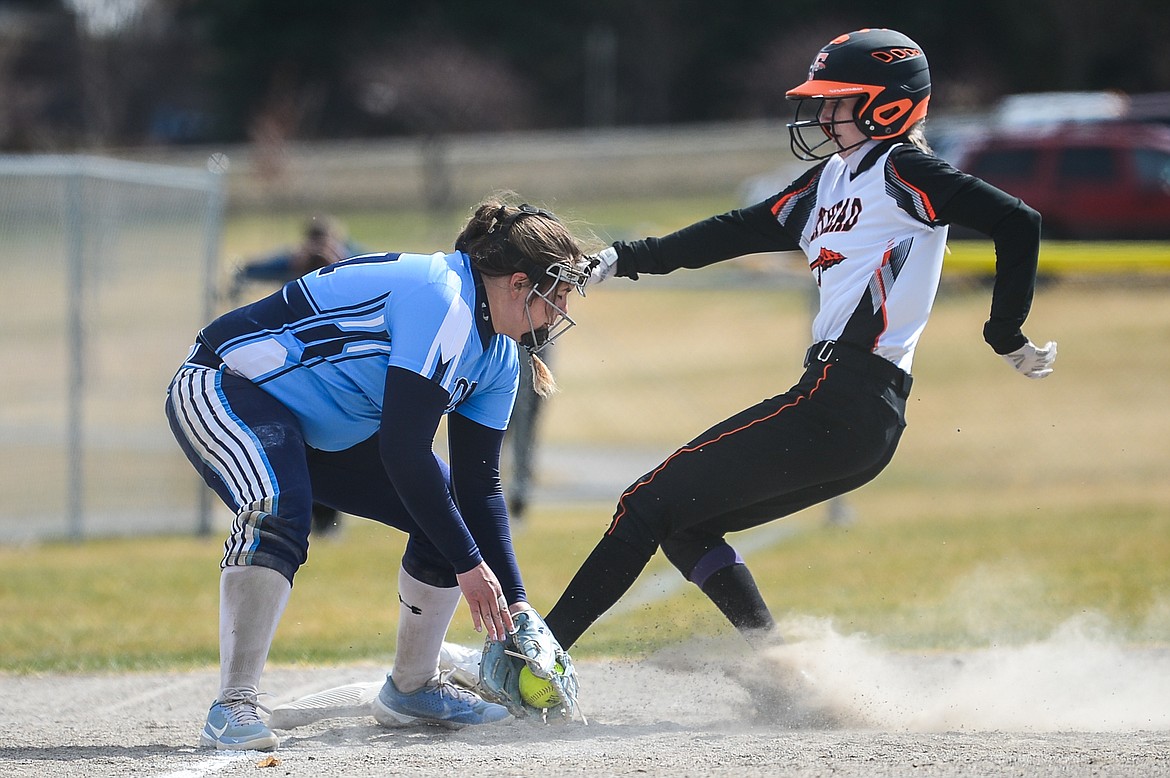 Flathead's Macy Craver (30) advances to third base ahead of the tag by Great Falls third baseman Morgan Sunchild (27) in the first inning at Kidsports Complex on Friday. (Casey Kreider/Daily Inter Lake)