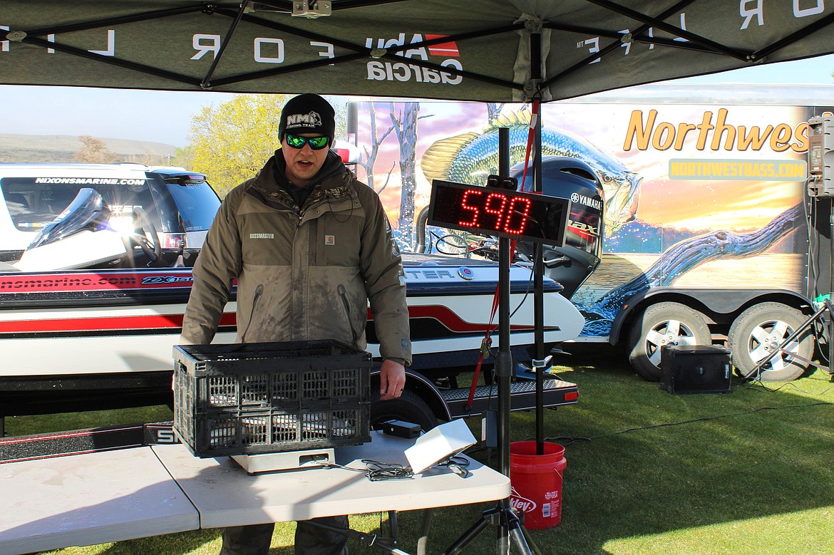 Chase Heaton weighs the 9 o'clock winner, a 5.9-pound largemouth bass at the bass tournament on Potholes Reservoir on Saturday.