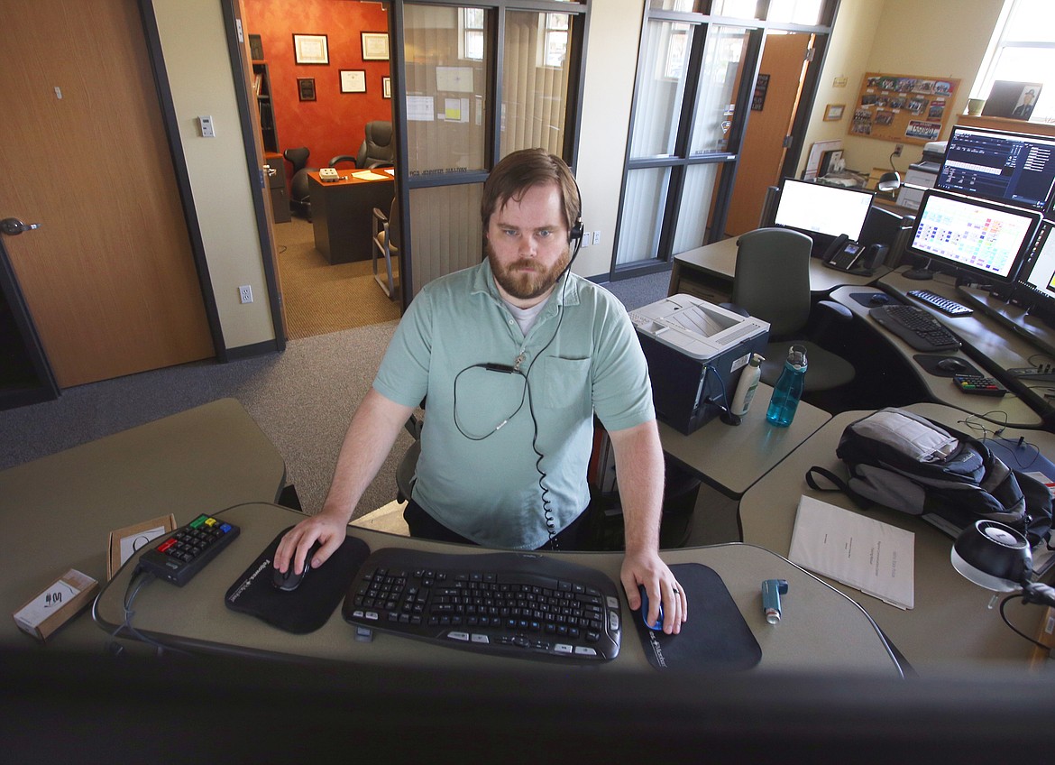 Mark Wise monitors screens and calls at the Idaho State Police Regional Communication Center in Coeur d'Alene on Friday.