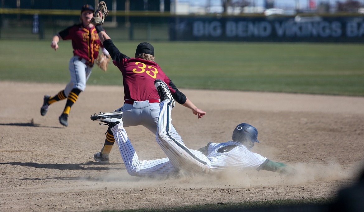 Big Bend Community College's Connor Cook slides into first base as Yakima Valley look to make the play in the first matchup of the afternoon in Moses Lake on Sunday.