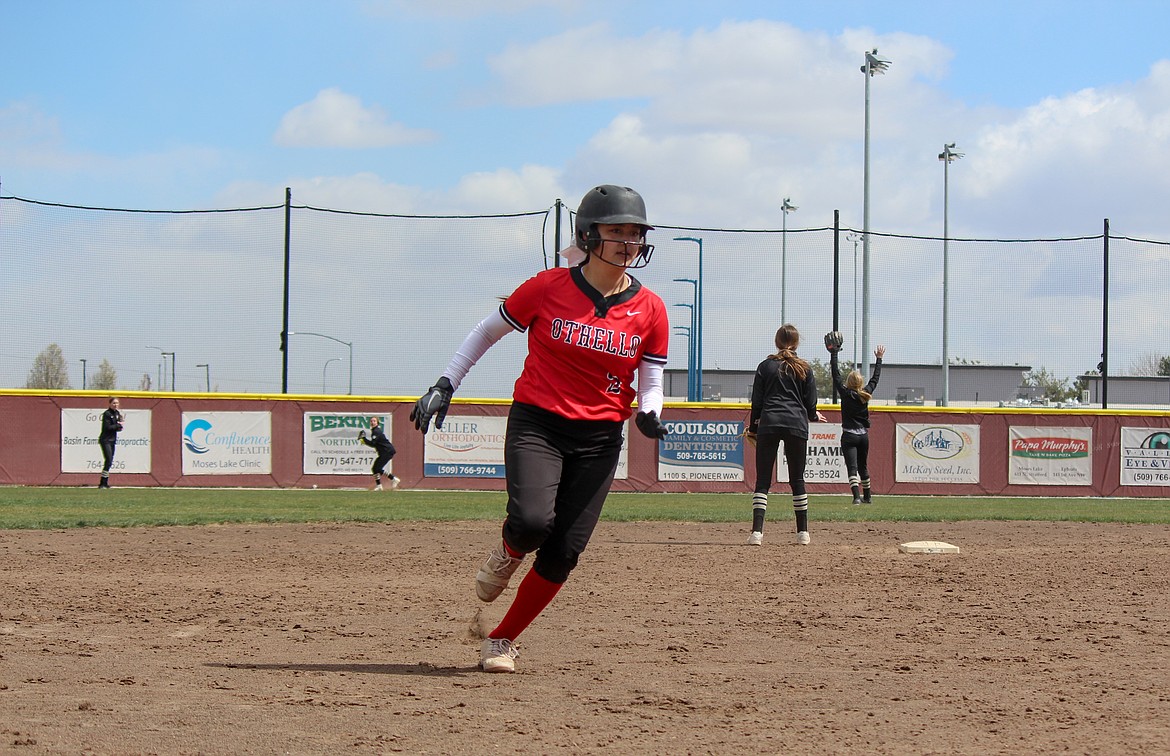 Othello High School's Ori Vasquez makes a dash toward third base as the Royal High School defense looks to get the ball to the infield behind her at the softball jamboree on Saturday in Moses Lake.