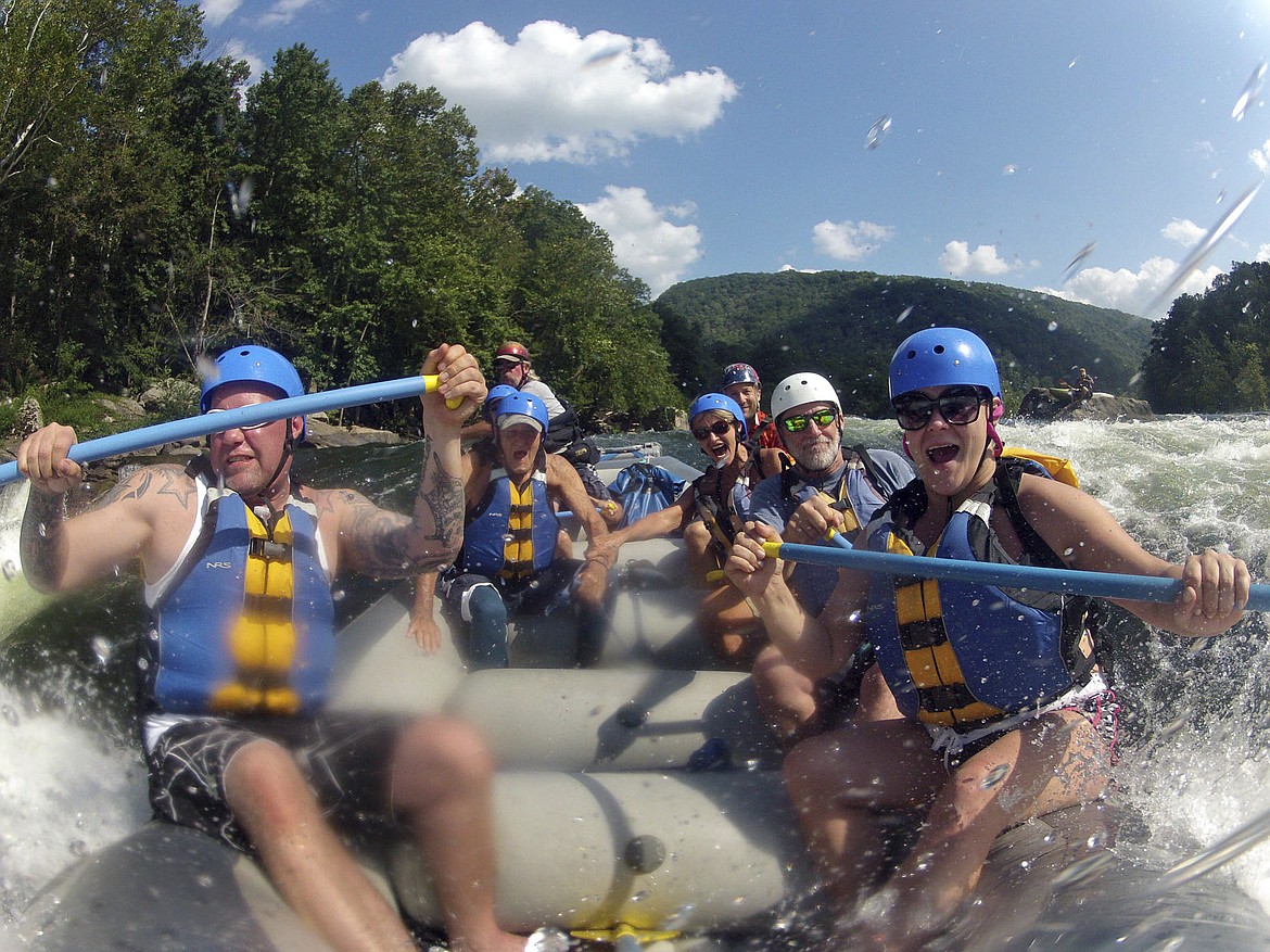 FILE - In this Aug. 30, 2012 file photo whitewater rafters are shown rafting the lower New River Gorge, near Fayetteville, W.Va. A program launched Monday, April 12, 2021, will try to lure outdoor enthusiasts to live and work in West Virginia with enticements of $12,000 cash and free passes for a year for recreation destinations such as whitewater rafting and golf. (Lawrence Pierce/Charleston Gazette-Mail via AP, File)