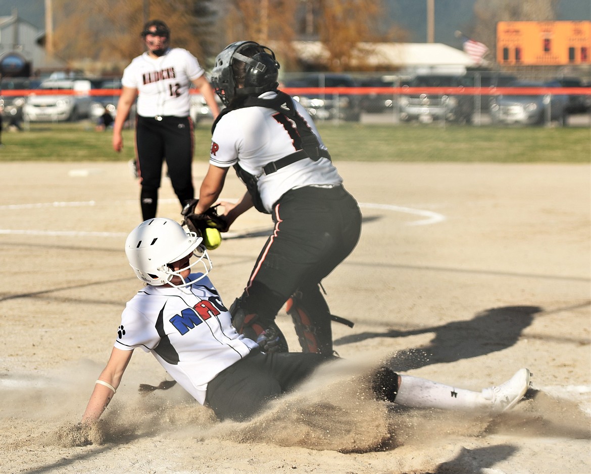 The Bulldogs' Hayleigh Smith slides safely to home plate below Ronan catcher Madison Miller. (Scot Heisel/Lake County Leader)