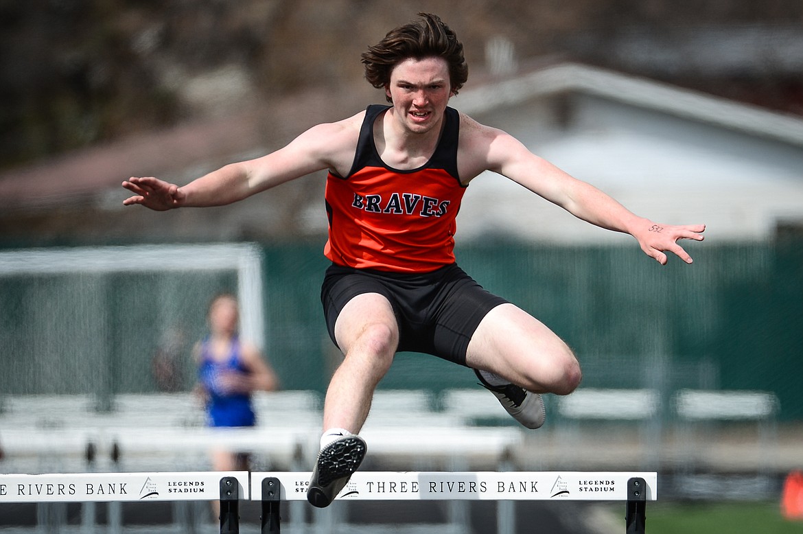 Flathead's Nic Gustafson clears a hurdle in the boys' 300 meter hurdles during a track and field meet at Legends Stadium on Tuesday. (Casey Kreider/Daily Inter Lake)