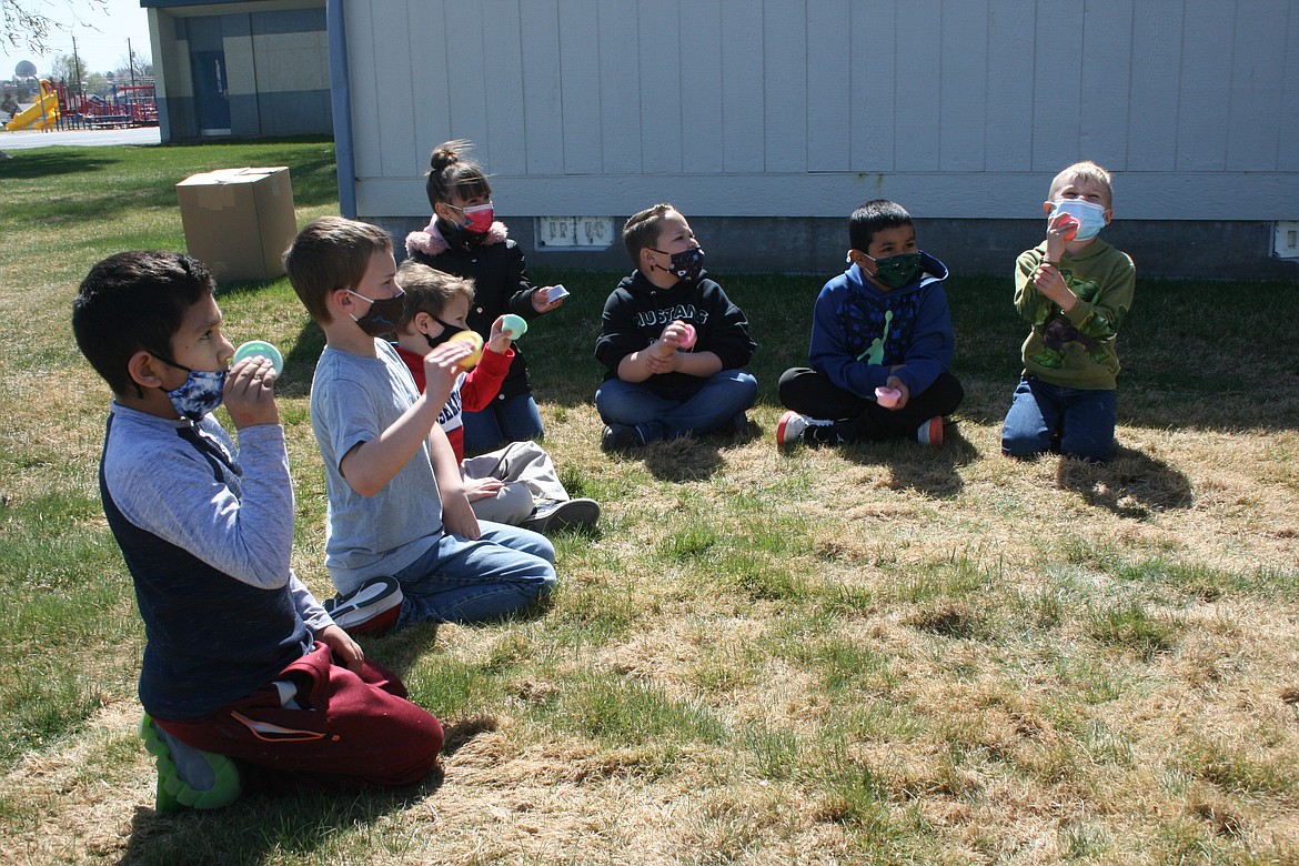 Peninsula Elementary first graders make butter, which takes a whole lot of shaking, during First Grade Farm Day Wednesday. Farm Day is sponsored by the Moses Lake High School FFA.