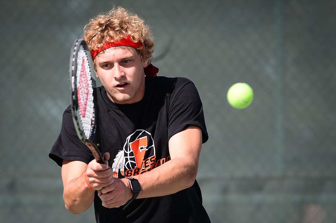 Flathead's Ethan Vandenbosch hits a return in a doubles match with teammate Kutuk White against Glacier's Alex Galloway and Harrison Sanders at Flathead Valley Community College on Thursday. (Casey Kreider/Daily Inter Lake)