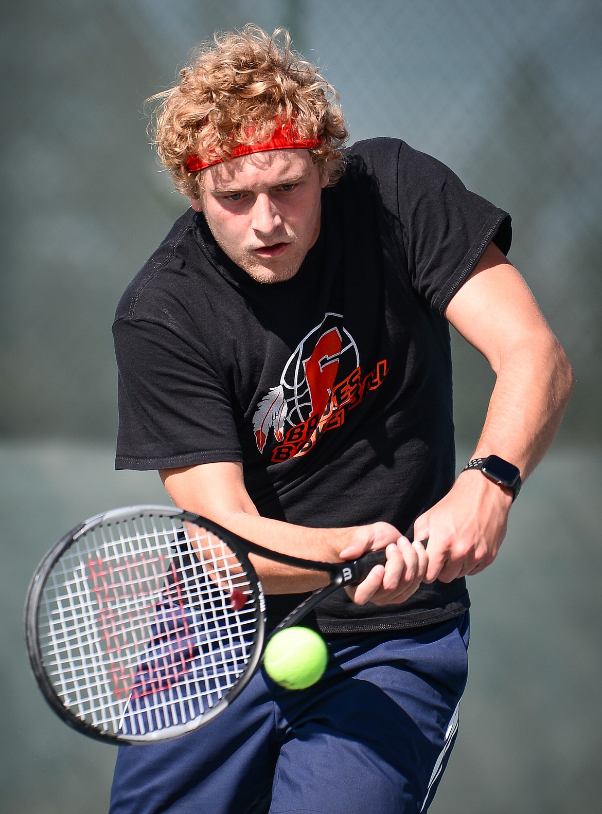 Flathead's Ethan Vandenbosch hits a return in a doubles match with teammate Kutuk White against Glacier's Alex Galloway and Harrison Sanders at Flathead Valley Community College on Thursday. (Casey Kreider/Daily Inter Lake)