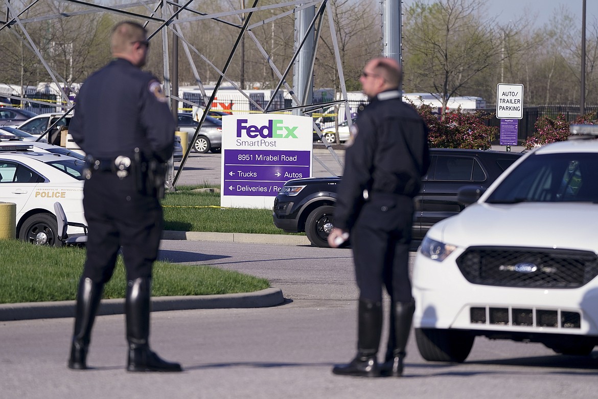 Police stand near the scene where multiple people were shot at the FedEx Ground facility early Friday morning, April 16, 2021, in Indianapolis. A gunman killed eight people and wounded several others before apparently taking his own life in a late-night attack at a FedEx facility near the Indianapolis airport, police said, in the latest in a spate of mass shootings in the United States after a relative lull during the pandemic.