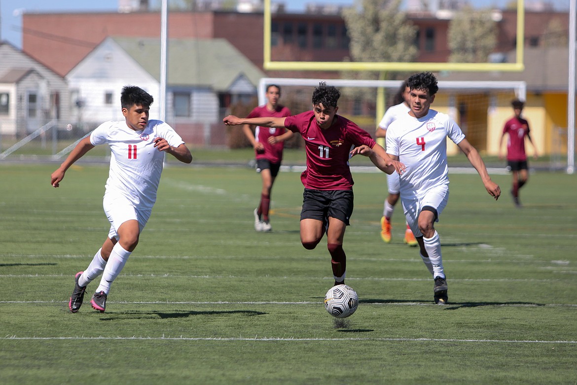 Oscar Garcia (11) races a pair of Eastmont defenders for the ball as he dashes up the field on Saturday afternoon at Lions Field in Moses Lake.