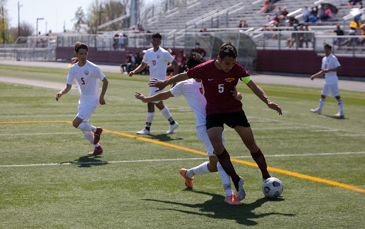 Moses Lake captain Simon Ribellia holds off the defender as he looks to make the turn toward the goal in the first half against Eastmont on Saturday at Lions Field.