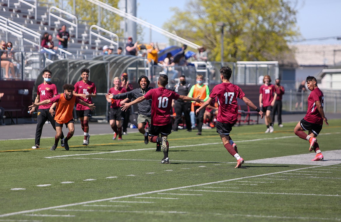 Jesus Taboada (10) rushes over to be swarmed by his teammates after scoring the go-ahead goal in the second half against Eastmont High School on Saturday in Moses Lake.