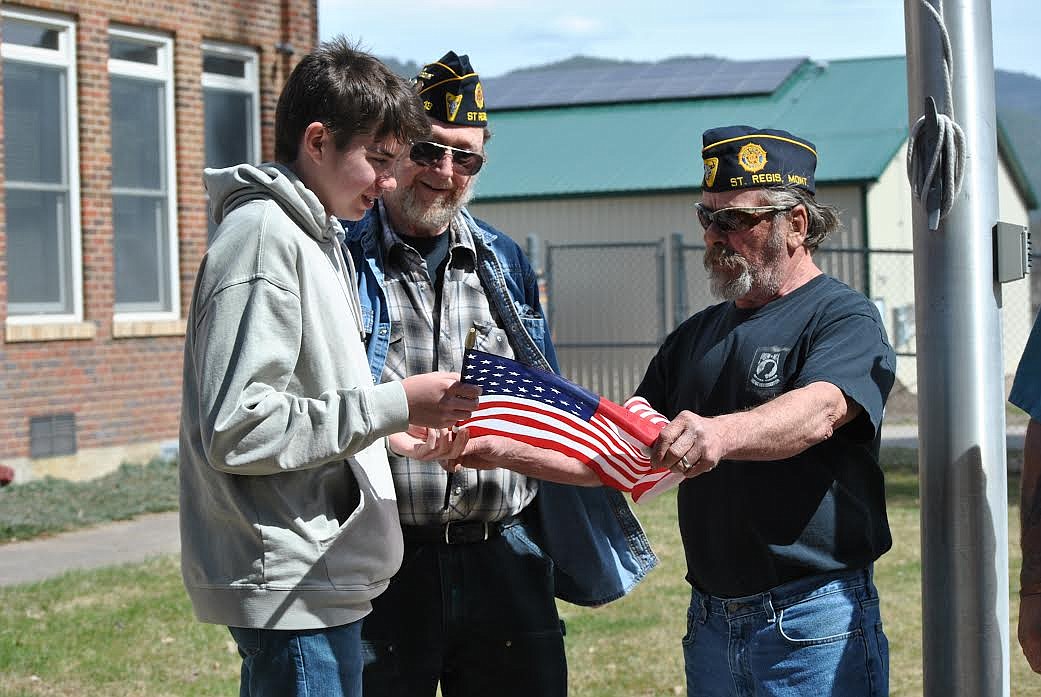 American Legion member Vince Triplett hands over a new flag to St. Regis student council vice president Jack Connolly. The school will now be taking part in the American Legion's civic education testing once again. (Amy Quinlivan/Mineral Independent)