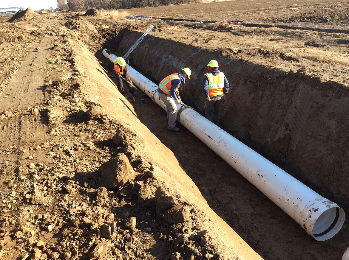 Workers with the Quincy-Columbia Basin Irrigation District lay pipe for the W26A17 pipeline.