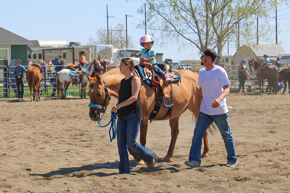 Parents Erick and Mariah Huberdeau lead their daughter Emberly through the key hole race at the Washington State Horsement show day on Saturday.