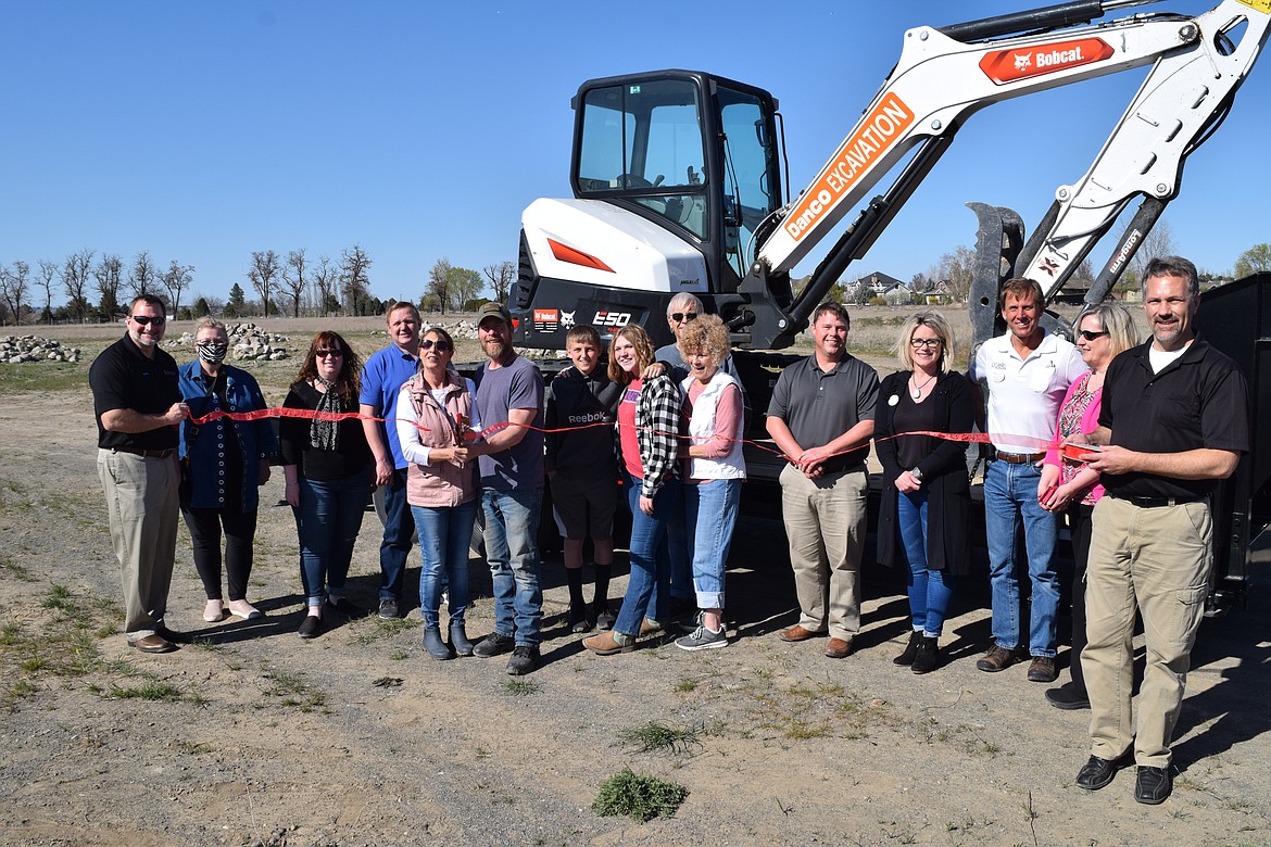 Danco Excavation owner Daniel Ferguson and his wife, Jeanette, surrounded by family and members of the Moses Lake Chamber of Commerce, cut the ribbon on his new business south of Moses Lake on Thursday afternoon.