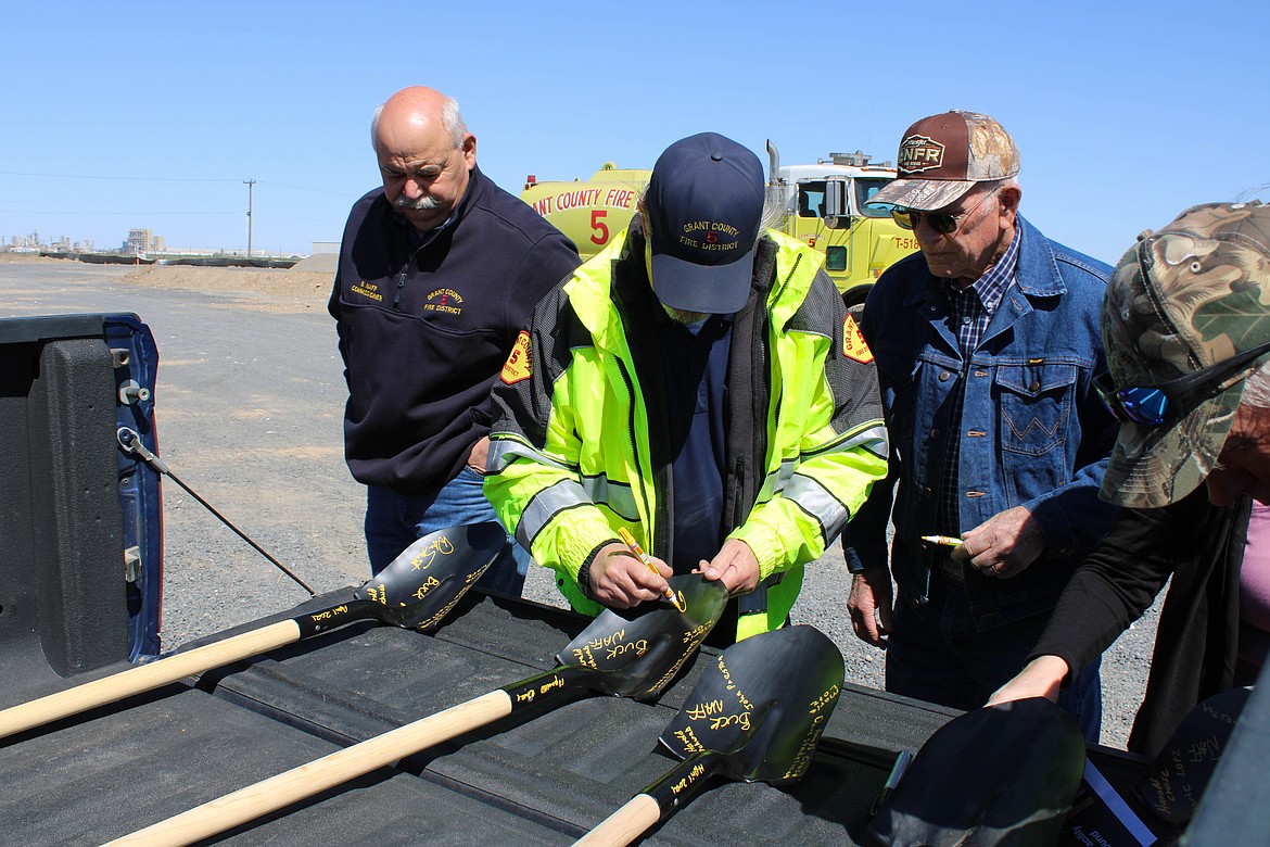 Fire District 5 Chief Dan Smith signs the groundbreaking ceremonial shovels to be displayed in the new facility.