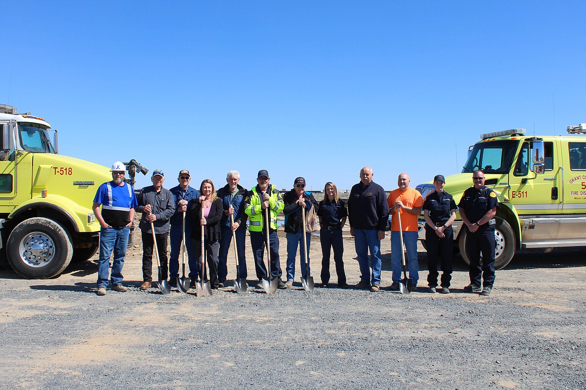 Left to right: Doug Finley, Dave Stadelman, John Preston, Marie Lotz, Harold Crose, Dan Smith, Harold Schwab, Amanda Bennett, Buck Naff, Bruce Matthews, Shailee Evans and Bob Horst pose for the groundbreaking ceremony for the new facility at 12801 Road 2 NE on Monday.