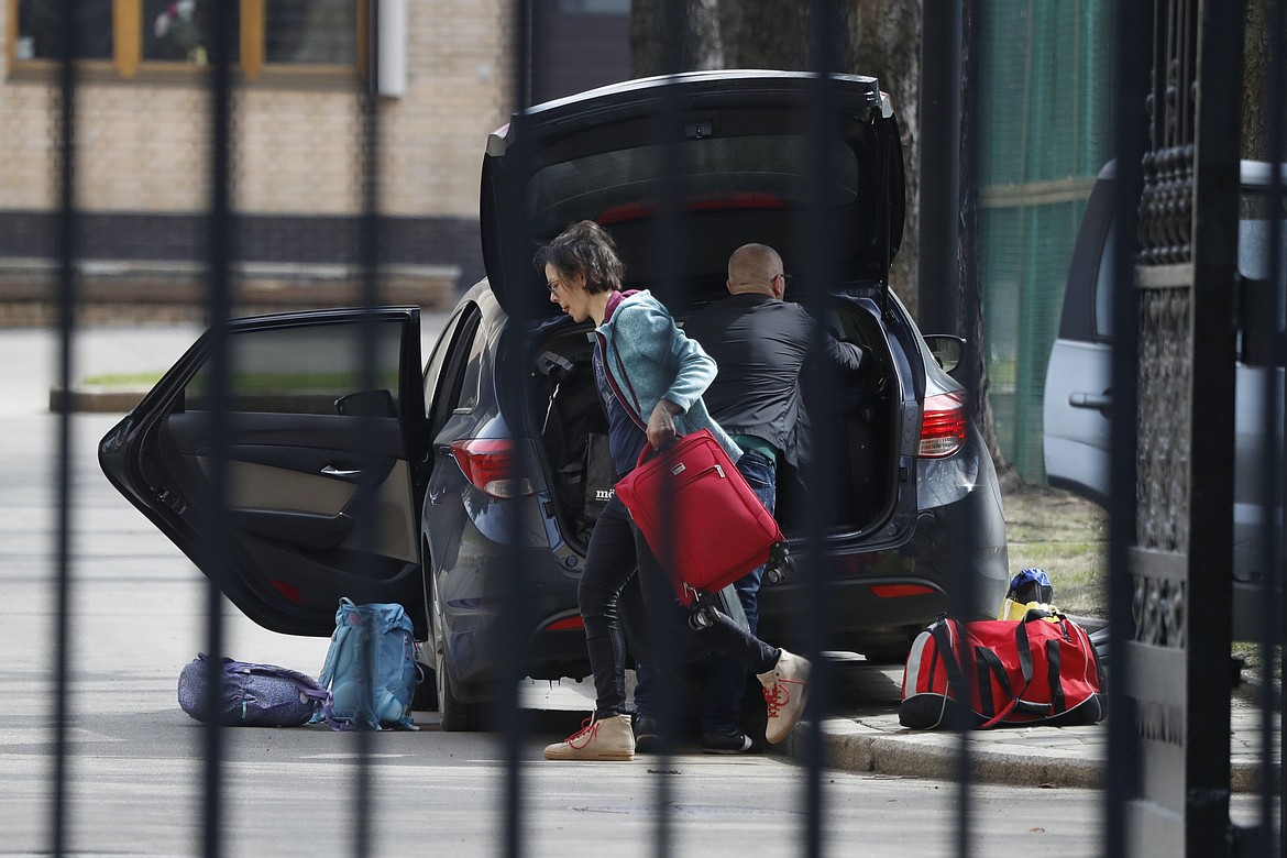 Embassy staff prepare to load luggage into a car inside the Czech Republic Embassy in Moscow, Russia, Monday, April 19, 2021. Russia has ordered 20 Czech diplomats to leave the country within a day in response to Prague's expulsion of 18 Russian diplomats. The Czech government has alleged the Russian Embassy staffers were spies for a military intelligence agency that was involved in a fatal ammunition depot explosion in 2014.