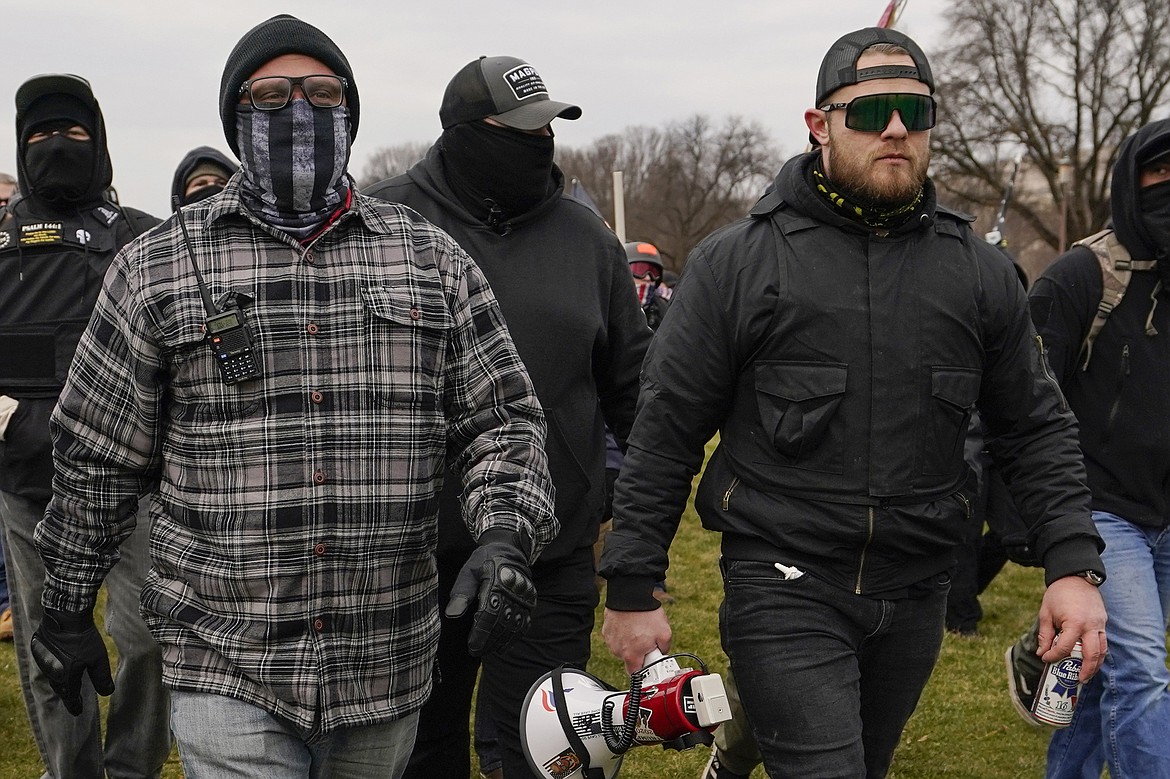 In this Jan. 6, 2021, file photo, Proud Boys members Joseph Biggs, left, and Ethan Nordean, right with megaphone, walk toward the U.S. Capitol in Washington. A federal judge has ordered Biggs and Nordean, two leaders of the far-right Proud Boys extremist group, to be arrested and jailed while awaiting trial on charges they planned and coordinated an attack on the U.S. Capitol to stop Congress from certifying President Joe Biden’s electoral victory. The two had been free since their March 10 indictment, but U.S. District Judge Timothy Kelly concluded April 19, that the two men are dangerous and won't abide by release conditions.