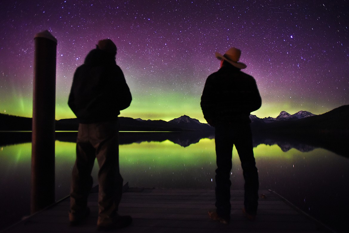 Visitors Sam Barker and Zack Smith take in a view of the northern lights from the Apgar pier on Lake McDonald inside Glacier National Park. (Jeremy Weber/Daily Inter Lake)