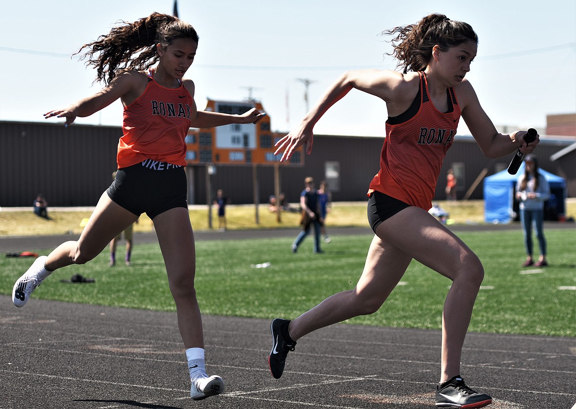 Ronan's Leina Ulutoa passes the baton to LaReina Cordova during the girls 4x100 relay Saturday. (Scot Heisel/Lake County Leader)