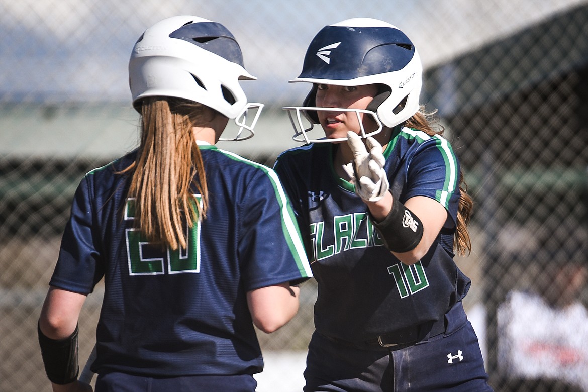 Glacier's Sammie Labrum (10) talks to Kenadie Goudette (20) after Labrum scored on an RBI single by Halle Schroeder (2) in the top of the seventh inning against Flathead during the first game of a crosstown doubleheader at Kidsports Complex on Tuesday. (Casey Kreider/Daily Inter Lake)