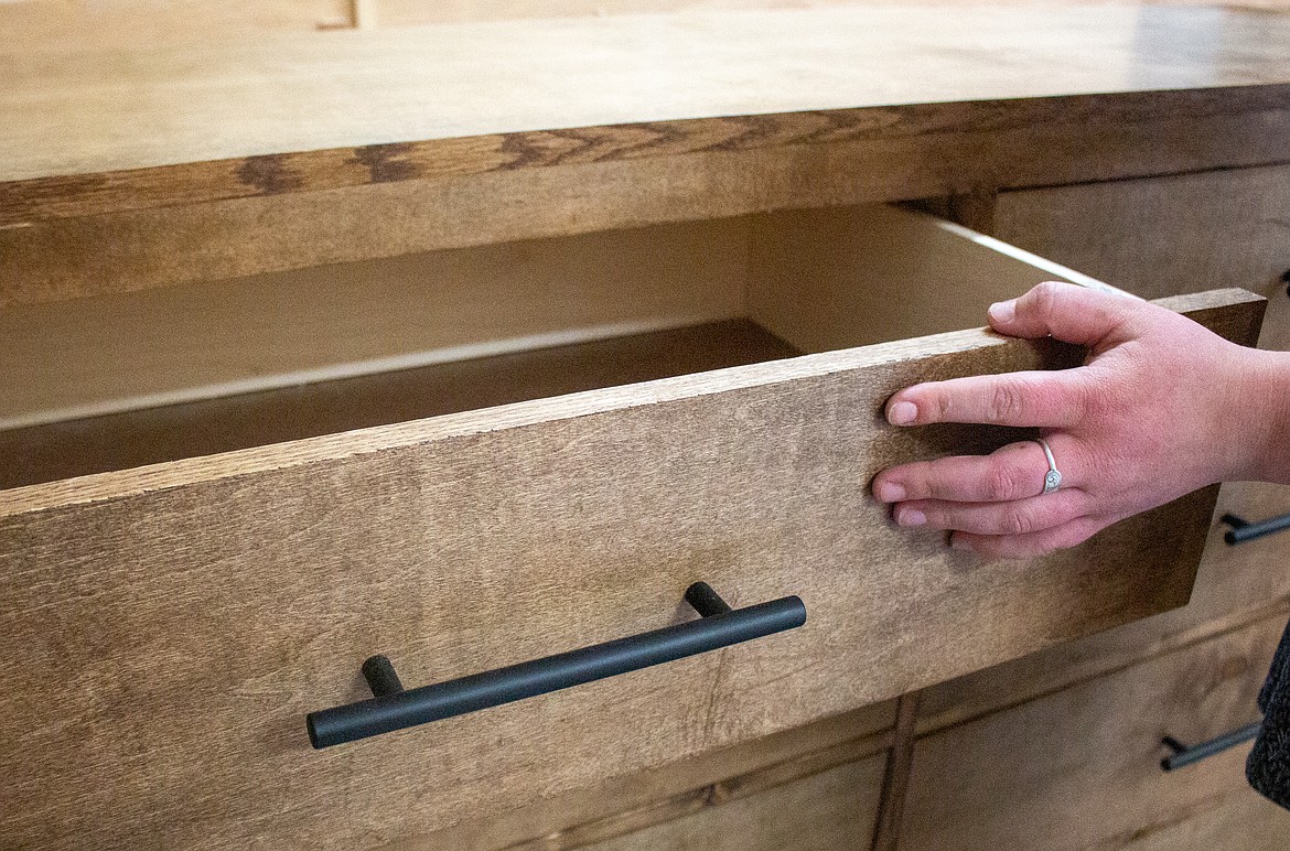 Nicole Case pulls out a drawer on a recently completed dresser in her garage in Moses Lake on Tuesday afternoon.