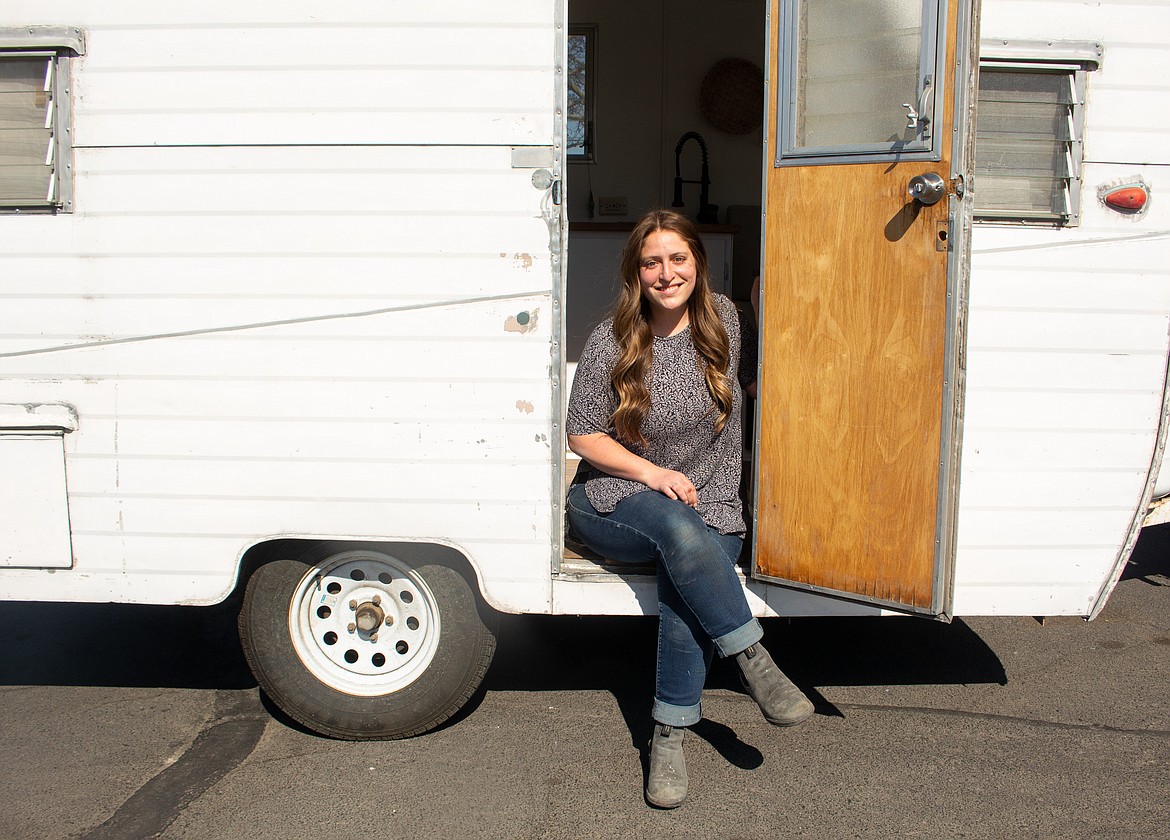 Nicole Case sits beside her remodeled camper trailer at Lower Peninsula Park in Moses Lake on Tuesday afternoon.