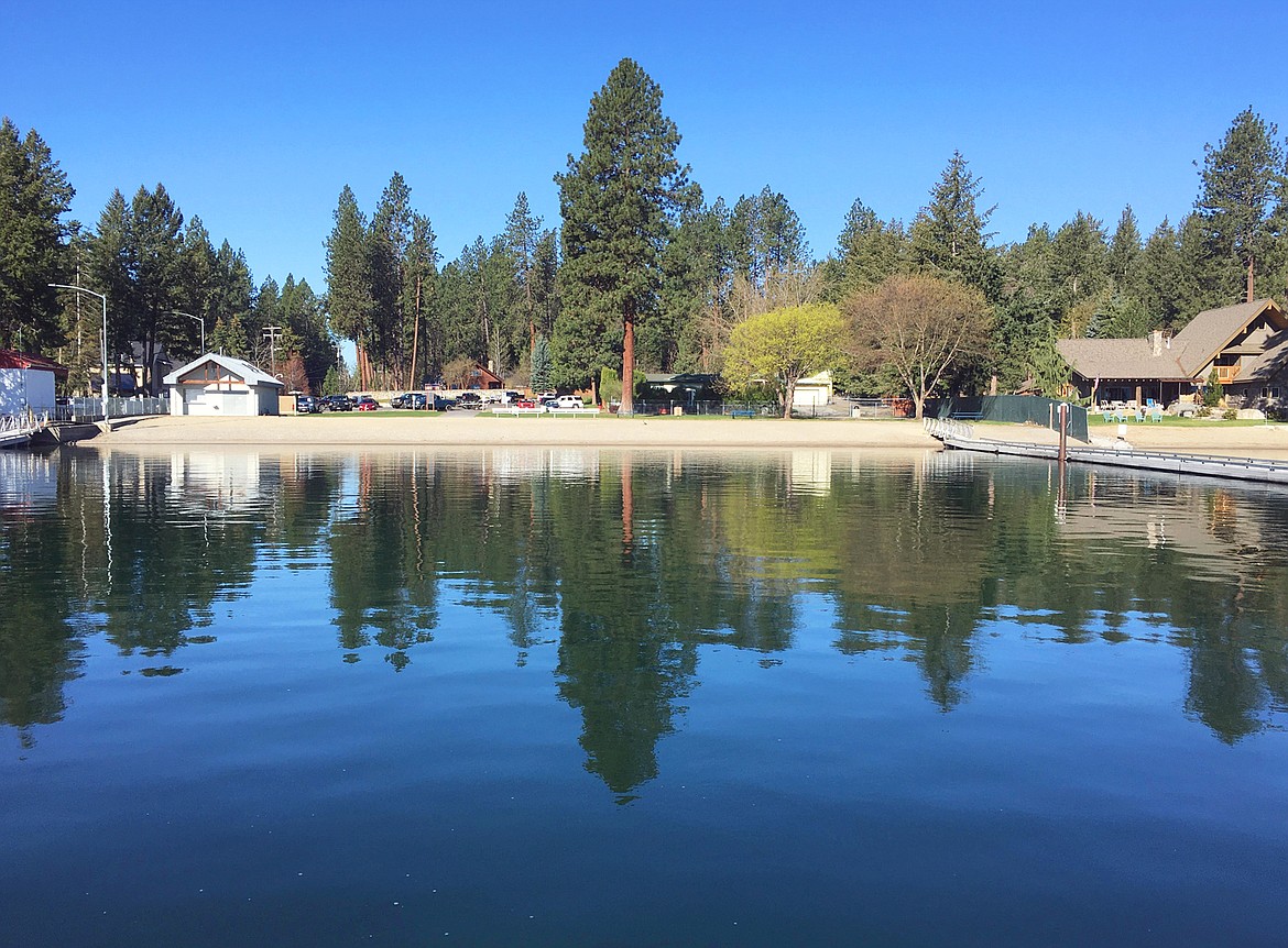 The waterfront at Honeysuckle Beach reflects off a calm Hayden Lake in spring 2021. In the coming year, Hayden officials will solicit public input about how to maintain a quality recreational experience and increase safety at the beach.