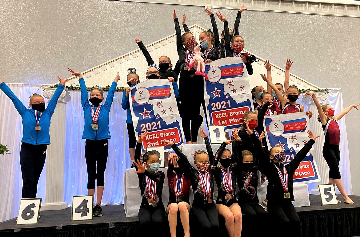 The S.T.E.P. Bronze team celebrates on the podium after taking first at the 2021 Idaho Xcel State Gymnastics Championships.